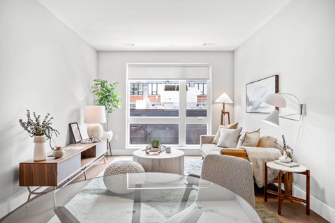 a living room with a couch and a table and a window